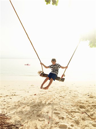 simsearch:6102-08746377,k - Boy swinging on beach Stock Photo - Premium Royalty-Free, Code: 6102-08746383