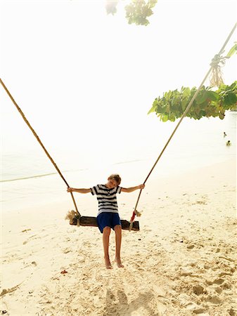 photos beach boys in asia - Boy swinging on beach Stock Photo - Premium Royalty-Free, Code: 6102-08746381