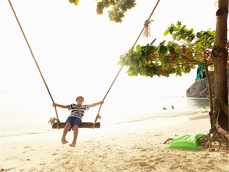 photos beach boys in asia - Boy swinging on beach Stock Photo - Premium Royalty-Free, Code: 6102-08746382