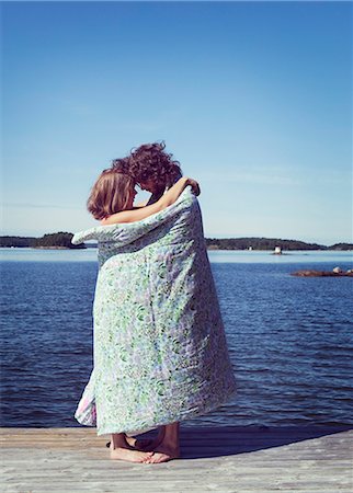 Couple wrapped in towel embracing on beach Foto de stock - Sin royalties Premium, Código: 6102-08746316