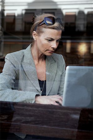 simsearch:400-04322314,k - Businesswoman sitting in cafe and using laptop Stock Photo - Premium Royalty-Free, Code: 6102-08746451