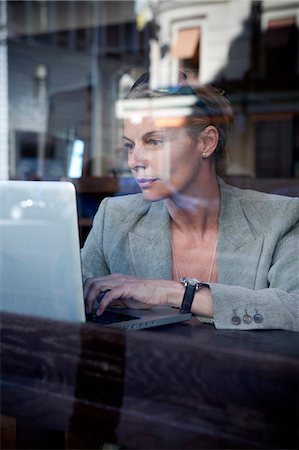 simsearch:400-04322314,k - Businesswoman sitting in cafe and using laptop Stock Photo - Premium Royalty-Free, Code: 6102-08746452