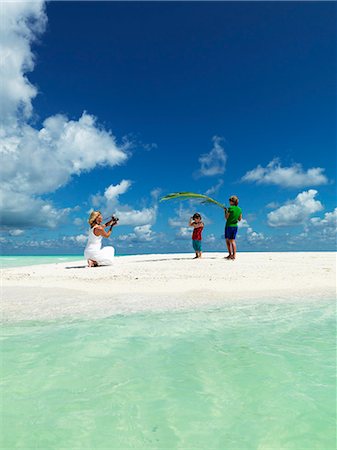 sandbar - Boys playing on sandy beach while mother taking photo Stock Photo - Premium Royalty-Free, Code: 6102-08746408