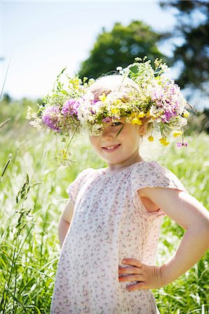 Girl wearing wreath of flowers standing in meadow Stock Photo - Premium Royalty-Free, Code: 6102-08746568