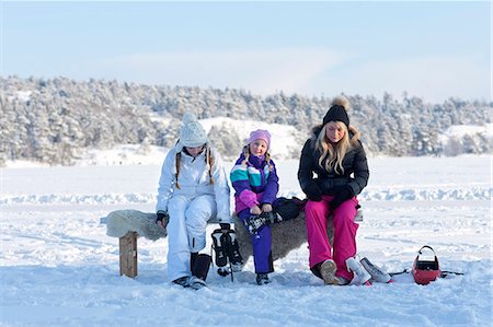 simsearch:6102-08942471,k - Three sisters sitting on bench and putting on ice-skates Fotografie stock - Premium Royalty-Free, Codice: 6102-08746605