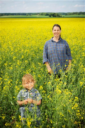 simsearch:6102-08746635,k - Smiling woman with girl on oilseed rape field Fotografie stock - Premium Royalty-Free, Codice: 6102-08746635