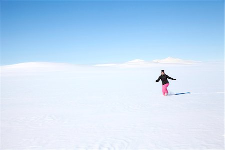 simsearch:6102-03827802,k - Woman walking through snow Stock Photo - Premium Royalty-Free, Code: 6102-08746705