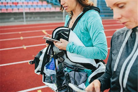 simsearch:6102-08885673,k - Women on running track checking cell phones Stock Photo - Premium Royalty-Free, Code: 6102-08747052