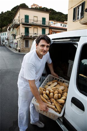 Baker delivering fresh rolls to local shop Stock Photo - Premium Royalty-Free, Code: 6102-08748552