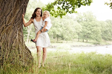 simsearch:6102-08746635,k - Mother and daughter standing beneath tree Fotografie stock - Premium Royalty-Free, Codice: 6102-08748591