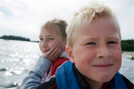 A boy and a girl sitting in a boat, Sweden. Stock Photo - Premium Royalty-Free, Code: 6102-08748742