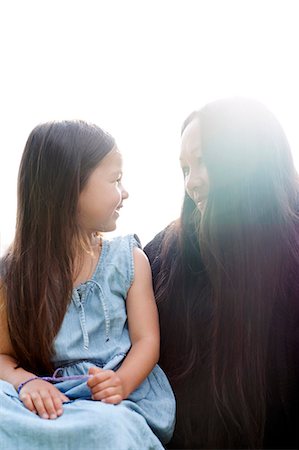 simsearch:6102-08746635,k - Smiling mother and daughter looking at each other Fotografie stock - Premium Royalty-Free, Codice: 6102-08760296