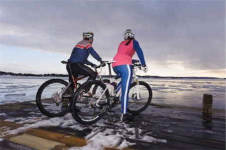 Mature couple on mountain bikes looking at view Stock Photo - Premium Royalty-Free, Code: 6102-08760234