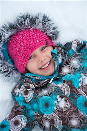 simsearch:6102-08885252,k - Smiling girl lying on snow Foto de stock - Sin royalties Premium, Código: 6102-08760385
