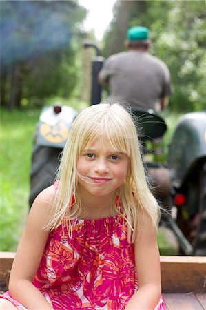 Portrait of girl, tractor in background Stock Photo - Premium Royalty-Free, Code: 6102-08760554