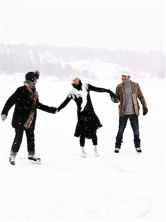 Three people skating, holding hands. Stock Photo - Premium Royalty-Free, Code: 6102-08760504