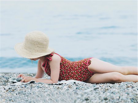 Girl playing with stones on beach Stock Photo - Premium Royalty-Free, Code: 6102-08760626