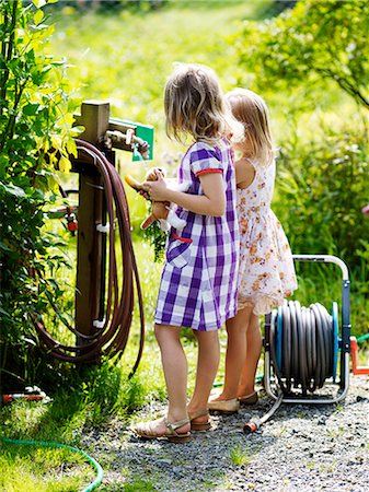 Girls washing carrots at pump Stock Photo - Premium Royalty-Free, Code: 6102-08760861
