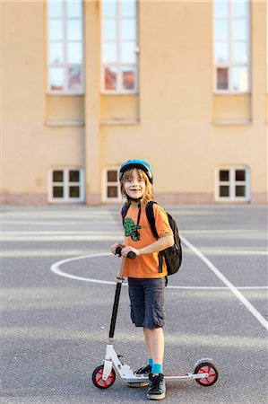 Boy with kick scooter on schoolyard, Stockholm, Sweden Stock Photo - Premium Royalty-Free, Code: 6102-08761441