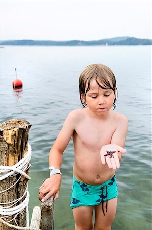 descamisado - Boy on jetty holding starfish Foto de stock - Sin royalties Premium, Código: 6102-08761465