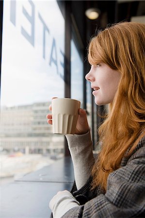 simsearch:6102-08996279,k - Young woman drinking coffee and looking through window Photographie de stock - Premium Libres de Droits, Code: 6102-08761645