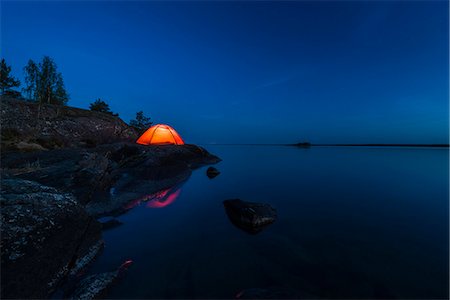 Illuminated tent on rocky coast Stock Photo - Premium Royalty-Free, Code: 6102-08726871