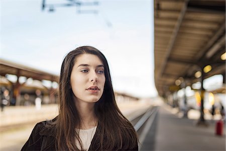 simsearch:6102-08885644,k - Young woman on train station Foto de stock - Royalty Free Premium, Número: 6102-08726809