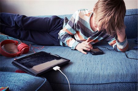 playing music on the mobile - Boy using cell phone Stock Photo - Premium Royalty-Free, Code: 6102-08726991