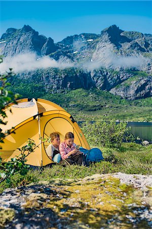 simsearch:6102-08858610,k - Brother and sister using cell phone in front of tent Foto de stock - Sin royalties Premium, Código: 6102-08858440