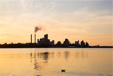 Silhouette of factory buildings at sunset Photographie de stock - Premium Libres de Droits, Code: 6102-08858496