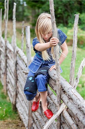 dungaree - Girl sitting on wooden fence Stock Photo - Premium Royalty-Free, Code: 6102-08858422