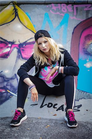 sweden graffiti - Young woman sitting against graffiti Stock Photo - Premium Royalty-Free, Code: 6102-08858613