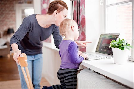 Mother and son using laptop in living room Stock Photo - Premium Royalty-Free, Code: 6102-08858764