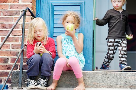 simsearch:6102-08521062,k - Children sitting on steps and eating apples Photographie de stock - Premium Libres de Droits, Code: 6102-08881524