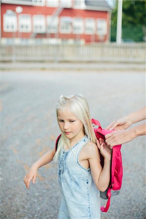 simsearch:6102-08952062,k - Girl putting backpack on Stock Photo - Premium Royalty-Free, Code: 6102-08881751