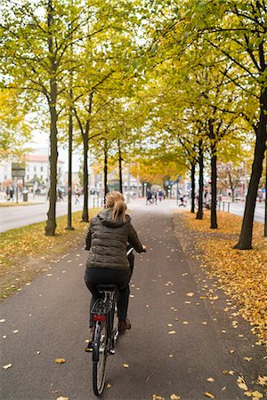 Woman cycling in town Stock Photo - Premium Royalty-Free, Code: 6102-08881886