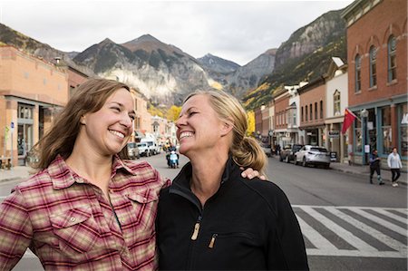Two friends standing on street and laughing Stock Photo - Premium Royalty-Free, Code: 6102-08881898