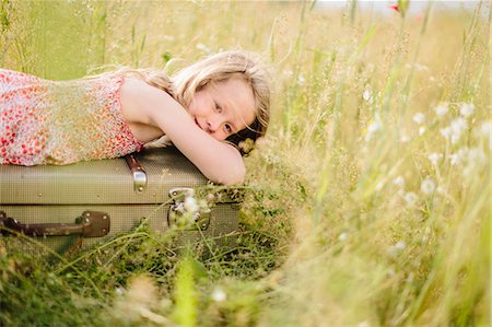 simsearch:6102-06336624,k - Girl lying on suitcase in meadow Foto de stock - Sin royalties Premium, Código: 6102-08881806