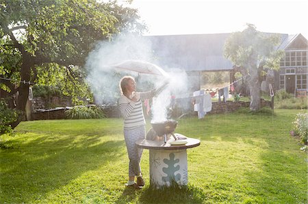 rain images for kids - Girl with umbrella having barbecue in garden Stock Photo - Premium Royalty-Free, Code: 6102-08881951