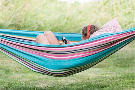 simsearch:6102-08683171,k - Girl on hammock using cell phone Photographie de stock - Premium Libres de Droits, Code: 6102-08882125