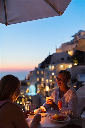 santorini island greece and people - Women playing cards at dusk Stock Photo - Premium Royalty-Free, Code: 6102-08885141