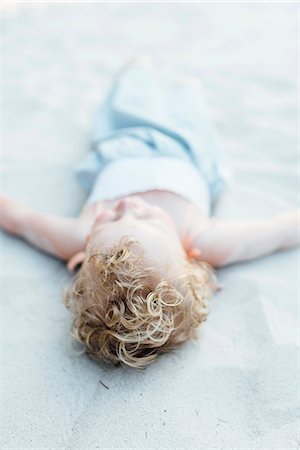 Girl lying on sand Stock Photo - Premium Royalty-Free, Code: 6102-08885440