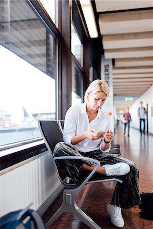 simsearch:6102-08996004,k - Woman using cell phone at airport Photographie de stock - Premium Libres de Droits, Code: 6102-08885455