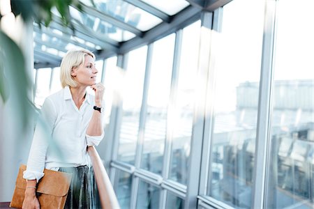 Businesswoman looking through window Photographie de stock - Premium Libres de Droits, Code: 6102-08885465