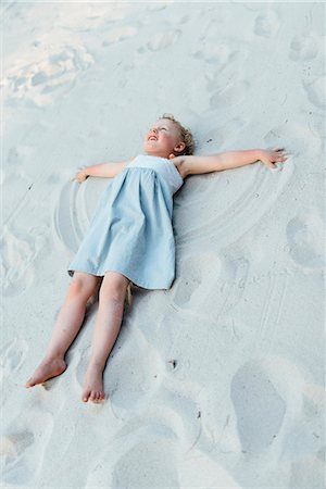 Girl making sand angel Foto de stock - Sin royalties Premium, Código: 6102-08885439