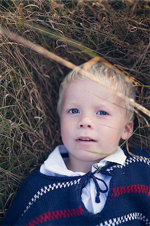 simsearch:6102-08885252,k - A boy lying in the grass Foto de stock - Sin royalties Premium, Código: 6102-08885553