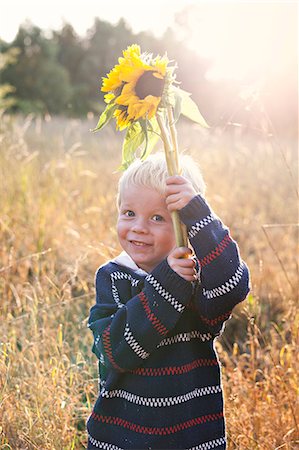 simsearch:6102-08270736,k - A boy with a flower Foto de stock - Royalty Free Premium, Número: 6102-08885552