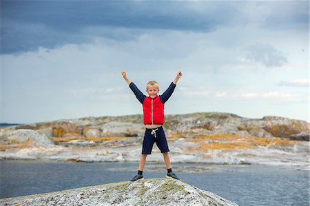 Boy on top of rock Stock Photo - Premium Royalty-Free, Code: 6102-08885570