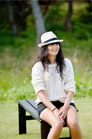 simsearch:6102-08885644,k - Young woman relaxing on bench Foto de stock - Royalty Free Premium, Número: 6102-08885739