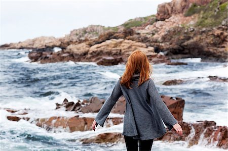 simsearch:6102-08800360,k - Young redhead woman standing on seaside and loking at sea Foto de stock - Sin royalties Premium, Código: 6102-08800165